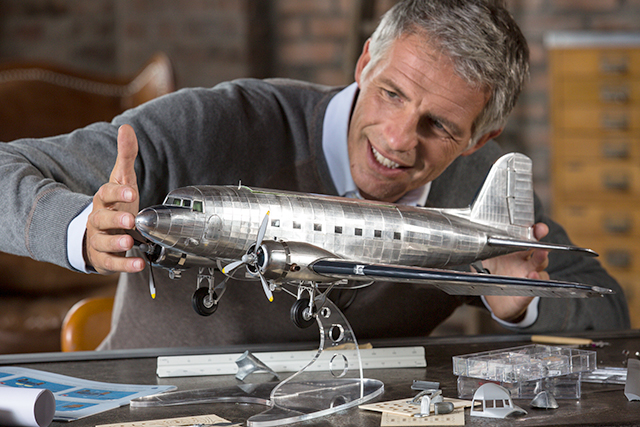 Man admiring a 1:32 Douglas DC3 scale model plane, as part of a blog about choosing your first scale model.