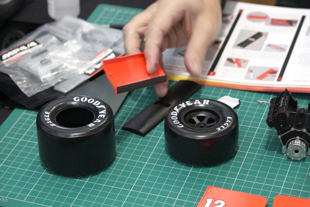 Image of man's hand building the ModelSpace Senna McLaren MP4/4 scale model, as part of a blog about activities to do at home.